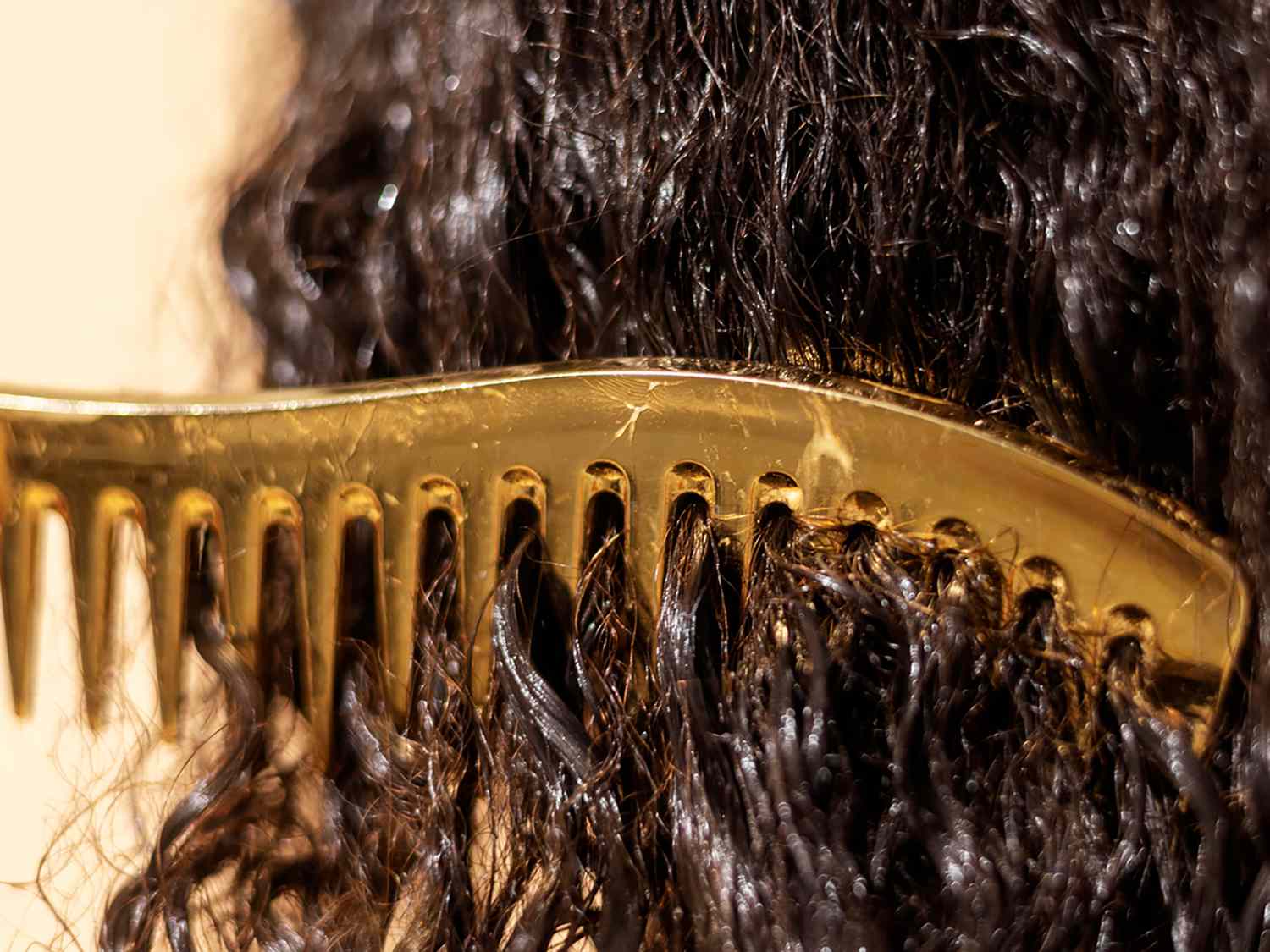 a comb in wet curly dark hair