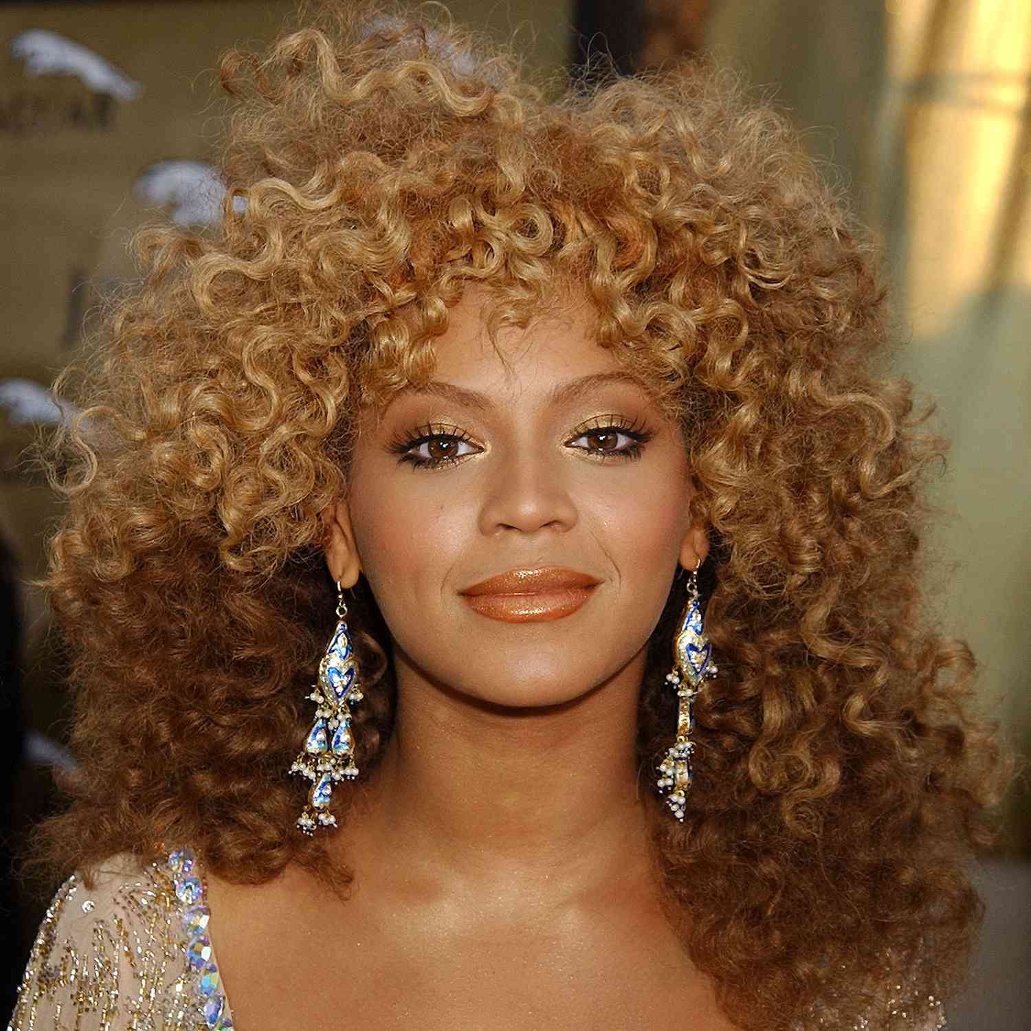 Beyonce wearing a full head of curls and a curly french bang to a film premiere