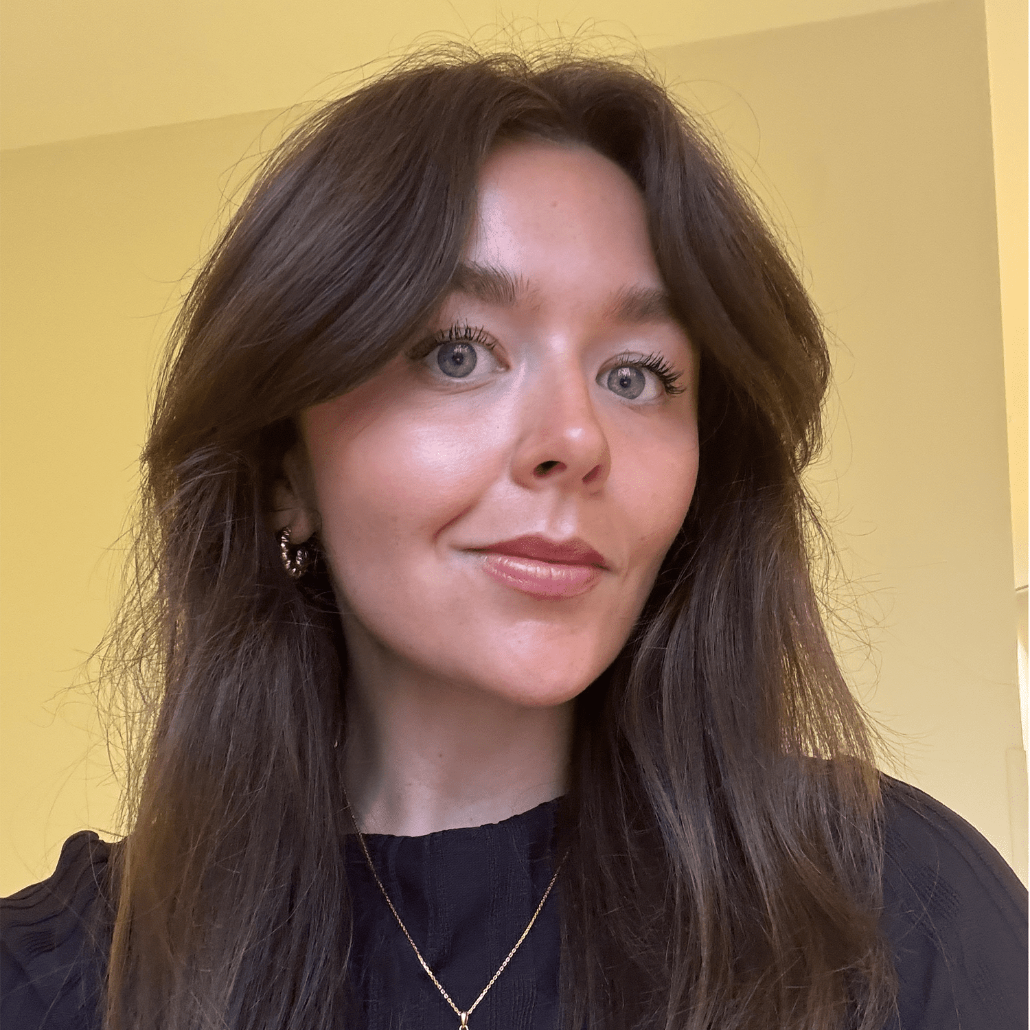 Woman with long brown hair and glowing skin