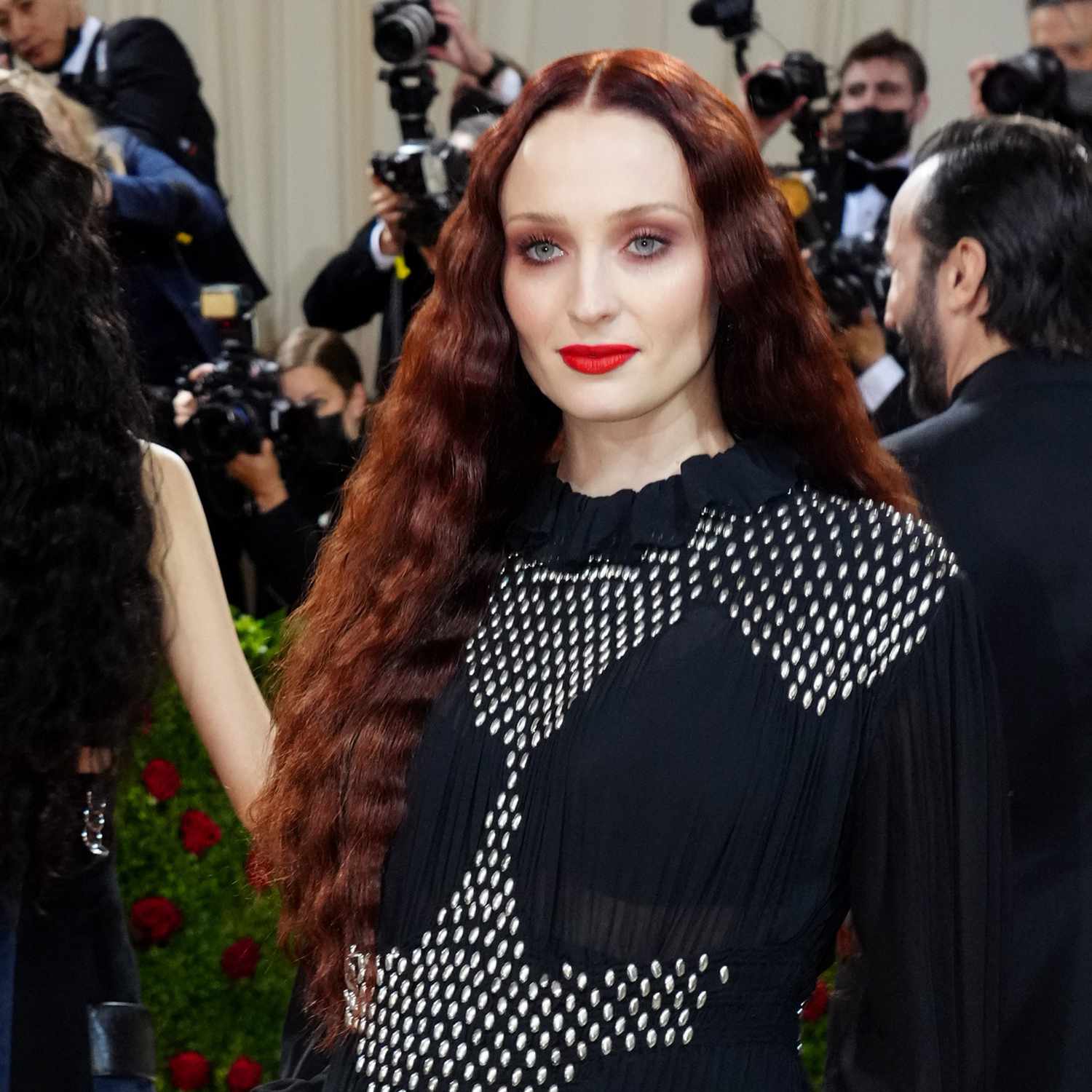 Sophie Turner with deep red hair, long and wavy