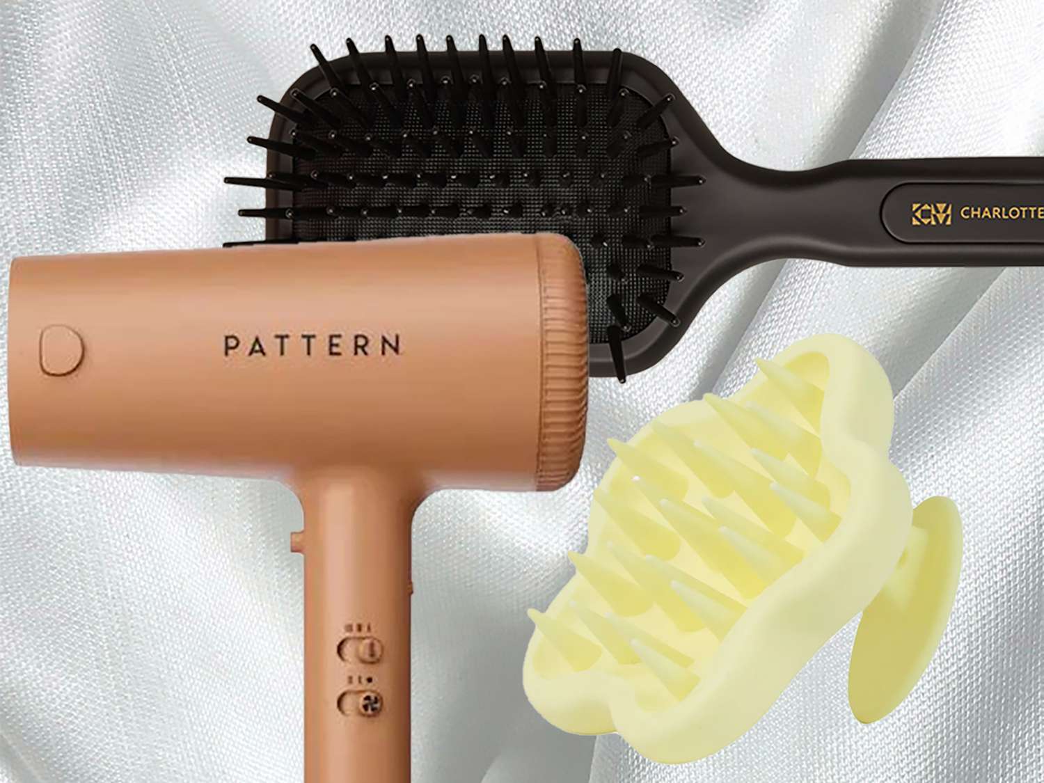 Pattern Beauty hair dryer, Charlotte Mensah Brush, and Bread Beauty Scalp massager on a white background