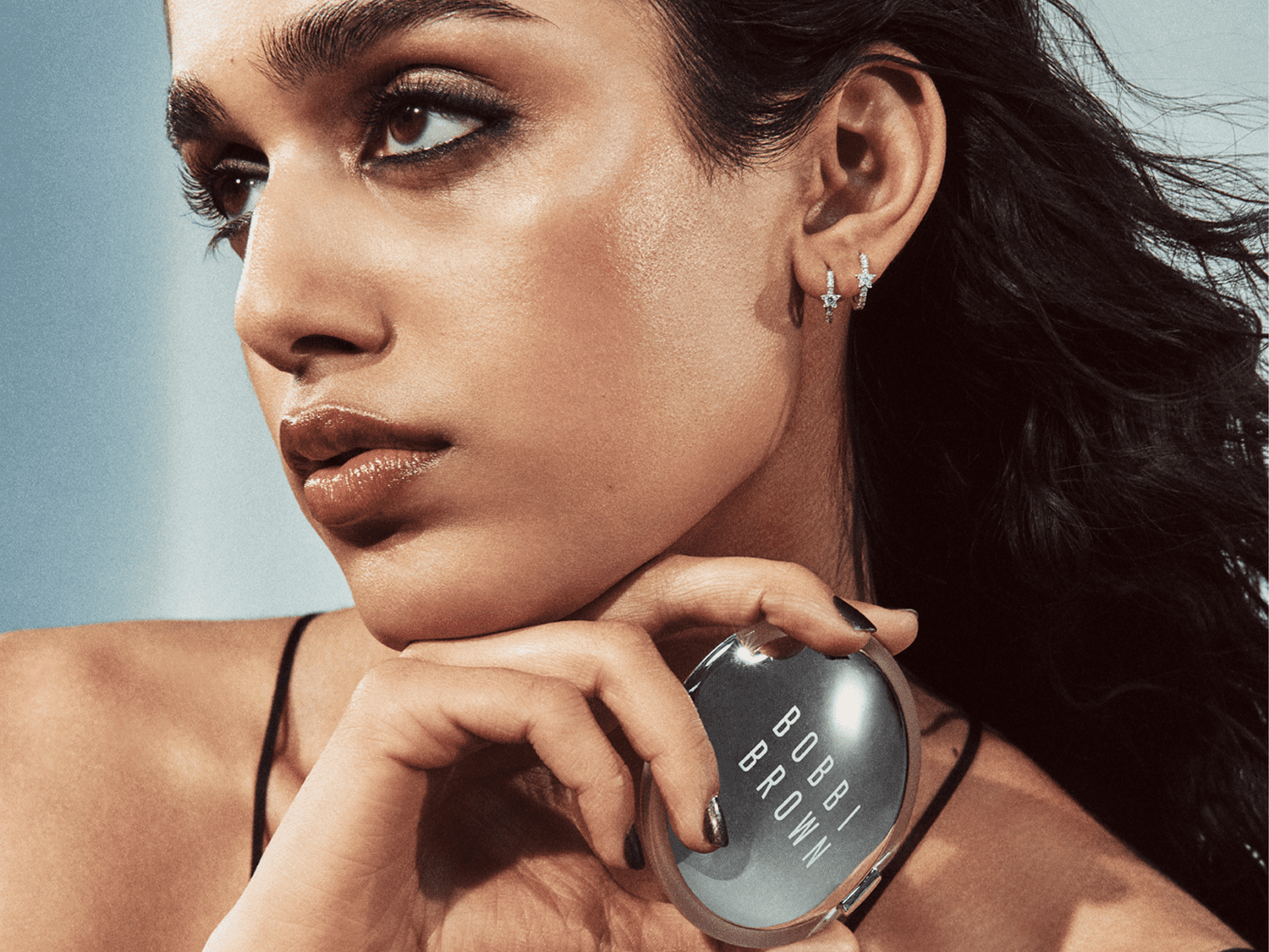 Model holding a silver compact